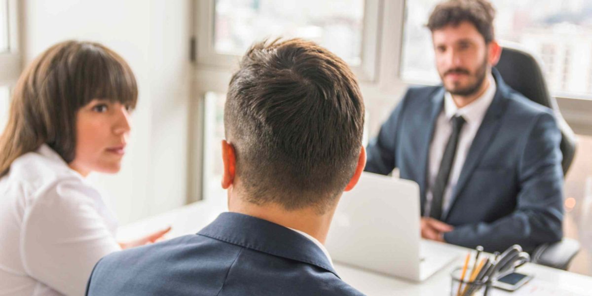 Business meeting between a lawyer and clients discussing legal consultation in an office